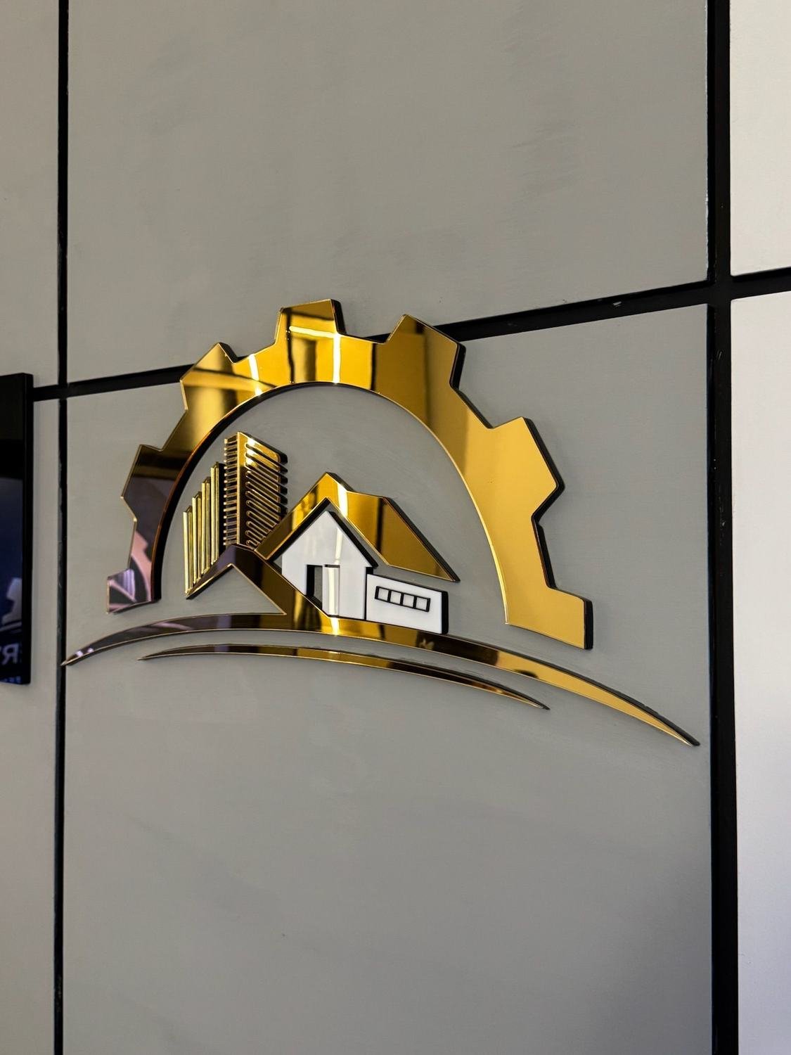 Emblema corporativo de Grupo Alfaca Services en relieve dorado