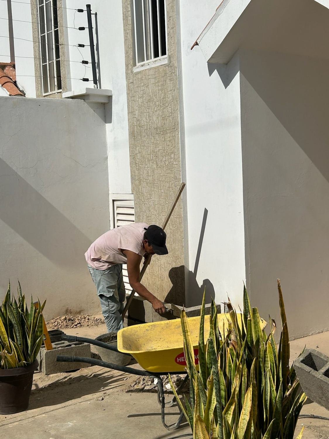 Trabajador ejecutando obra civil en fachada exterior